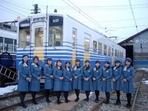 電車の前に並ぶ女性社員たち